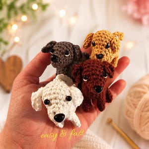 Könnte beinhalten: Vier kleine, gehäkelte Hundefiguren in Weiß, Braun, Dunkelbraun und Beige. Jede hat schwarze Knopfaugen und eine kleine, abgerundete Nase. Der Text "easy & fast" ist in gelber Schrift geschrieben. Die Hunde werden in einer Hand gehalten.