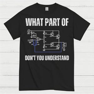 May include: Black t-shirt with white text and a circuit diagram. The text reads "WHAT PART OF DON'T YOU UNDERSTAND". The design includes electronic symbols and measurements.