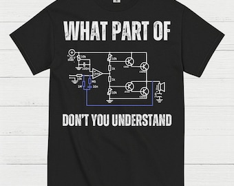 May include: Black t-shirt with white text and a circuit diagram. The text reads "WHAT PART OF DON'T YOU UNDERSTAND". The design includes electronic symbols and measurements.