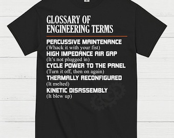 May include: Black t-shirt with white text that reads "GLOSSARY OF ENGINEERING TERMS." The text includes humorous definitions for engineering terms like "Percussive Maintenance" and "Kinetic Disassembly." A gear graphic is in the lower right corner.