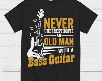May include: Black t-shirt featuring a white bass guitar graphic with musical notes. The text reads "NEVER UNDERESTIMATE AN OLD MAN WITH A Bass Guitar" in yellow and white.