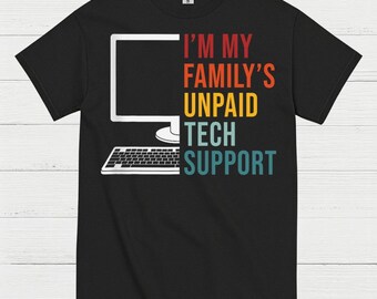 May include: Black t-shirt with a white computer graphic and the text "I'M MY FAMILY'S UNPAID TECH SUPPORT" in orange, yellow, and teal. The shirt is made of a soft material.