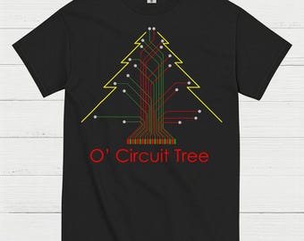 May include: Black t-shirt featuring a yellow outline of a Christmas tree made of red, green, and white circuit board lines. The text "O' Circuit Tree" is printed in red below the tree design.