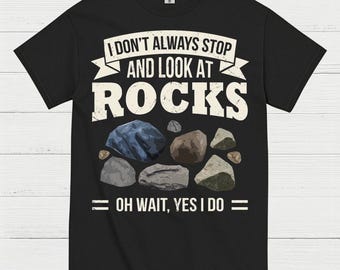 May include: Black t-shirt with the text "I DON'T ALWAYS STOP AND LOOK AT ROCKS, OH WAIT, YES I DO" in white. The shirt features a graphic of various rocks in shades of gray, brown, and blue.