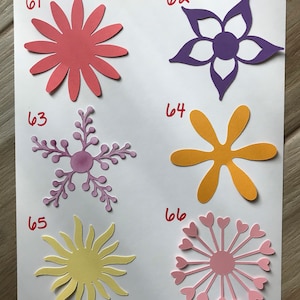 May include: Six paper flower cutouts in different shapes and colors. The flowers are numbered 61 through 66. The flowers are all different colors, including pink, purple, yellow, and orange.