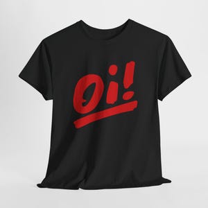 Puede incluir: Camiseta negra con la palabra "Oi!" en rojo, con letras estilizadas. La palabra está sobre una línea roja. La camiseta tiene mangas cortas y cuello redondo.