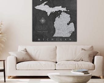 Könnte beinhalten: Eine Schwarzweißkarte von Michigan mit dem Text "In life it's not where you go, it's who you travel with" und "Mark & Rachel" unterhalb der Karte. Die Karte befindet sich auf einem grauen Hintergrund mit einer Kompassrose oben links.