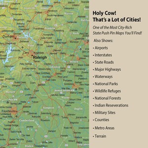 Puede incluir: Un mapa verde de Carolina del Norte con alfileres que marcan ciudades y pueblos. El mapa muestra las principales autopistas, v&iacute;as fluviales, parques nacionales, refugios de vida silvestre, bosques nacionales, reservas ind&iacute;genas, sitios militares, condados, &aacute;reas metropolitanas y terreno. El texto "Holy Cow! That's a Lot of Cities!" est&aacute; en la parte superior del mapa.