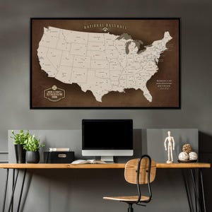 May include: A framed map of the United States, showing baseball stadium locations. The map is in brown and beige tones, with the words "National Baseball" at the top. The text "David and Cindy's Stadium Tour" is at the bottom of the map.