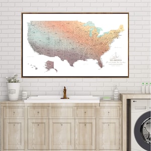 May include: A framed map of the United States with a gradient color scheme, transitioning from purple to orange and teal. The map includes state outlines and city labels. The text "SEE AMERICA" is visible in the lower right corner.
