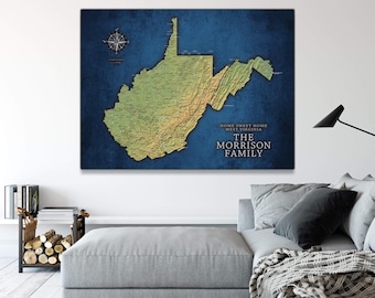 May include: A blue and green map of West Virginia with the text "Home Sweet Home West Virginia The Morrison Family" printed on the bottom right corner. The map is framed and hanging on a wall above a gray couch.