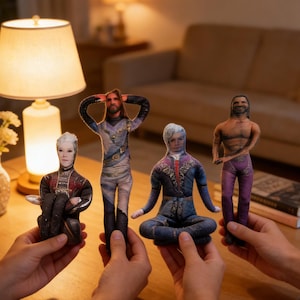 Puede incluir: Cuatro muñecos de tela con rasgos faciales y ropa detallados. Los muñecos representan diferentes personajes, cada uno con atuendos y poses únicos. Los muñecos son sostenidos por manos, mostrando su tamaño y diseño. El fondo incluye una lámpara, flores y un sofá.