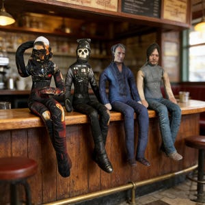 Puede incluir: Cuatro muñecos de tela sentados en una barra de madera. Los muñecos visten disfraces, incluyendo un traje espacial negro y rojo, un uniforme de piloto negro con casco de calavera, un traje azul y una camisa gris con vaqueros. La barra tiene un acabado de madera oscura.