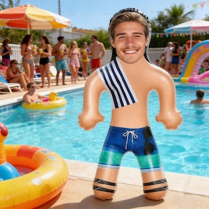 以下が含まれることがあります： 笑顔の顔、青い水着、ストライプのタオルが付いた、人の形をしたインフレータブルプールのおもちゃ。おもちゃには黒いサングラスが付いており、背景に人々がいるプールの前に立っています。