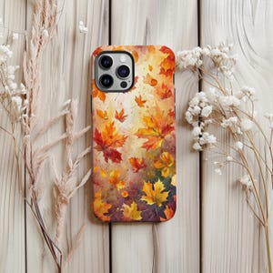 May include: A phone case featuring a watercolor design of autumn leaves in shades of red, orange, and yellow. The leaves appear to be falling against a light background. The case has a glossy finish.