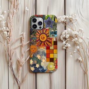 May include: A colorful phone case featuring a collage of art with suns, moons, stars, and geometric patterns. The case has a glossy finish and a raised star embellishment. The design incorporates warm colors like orange, yellow, and red.