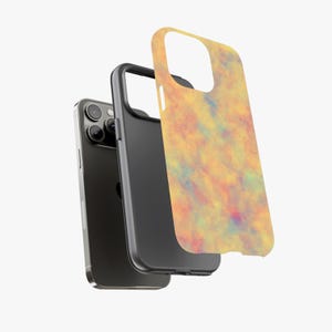 May include: A black smartphone with a black case and a separate case cover. The cover has a colorful abstract design in shades of yellow, orange, blue, and red. The phone and cases are displayed against a white background.