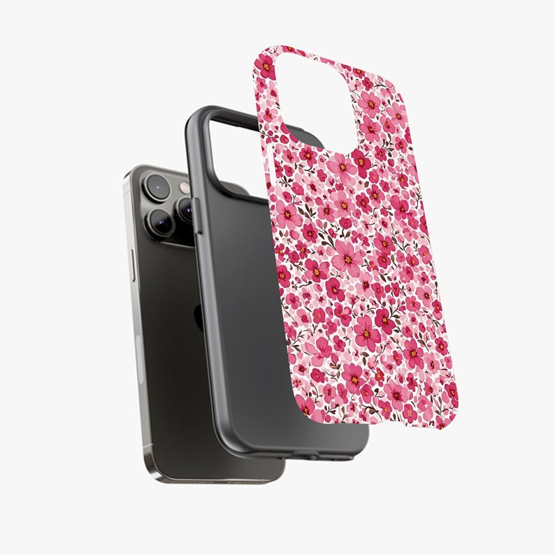 Puede incluir: Un smartphone negro con una funda floral. La funda presenta un patr&oacute;n de peque&ntilde;as flores rosas sobre un fondo blanco. La funda est&aacute; separada, mostrando el tel&eacute;fono y el interior negro de la funda.