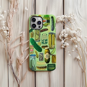 May include: A green phone case featuring a pickle-themed design. The case is covered with illustrations of pickles, jars of pickles, and pickle-related text. The design includes various pickle styles and packaging.