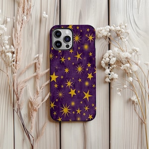 May include: A purple phone case with a pattern of yellow stars. The case has a textured appearance and a camera cutout. The design features stars of various sizes and shapes, creating a celestial theme.