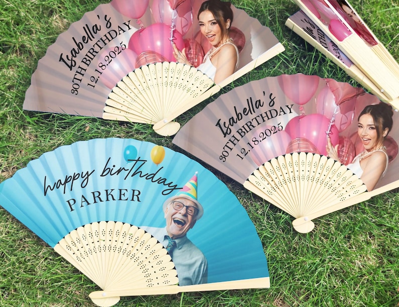 May include: A collection of personalised paper fans. Two fans display a woman with pink balloons and the text "Isabella's 30th Birthday 12.18.2025." Another fan has a blue background with the text "Happy Birthday Parker" and a photo of a man.