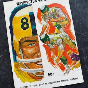 May include: A vintage football program for Washington vs. Oregon dated October 23, 1965. The cover features a large illustration of a player wearing a yellow helmet with the number 8, alongside two football players in action and the price 50 cents.