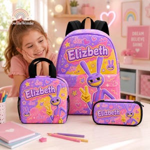 May include: A purple backpack, lunch bag, and pencil case set featuring a cartoon rabbit character, the name Elizbeth, and the text Jax. The items are decorated with yellow stars, pink hearts, and purple patterns on a bright purple background.