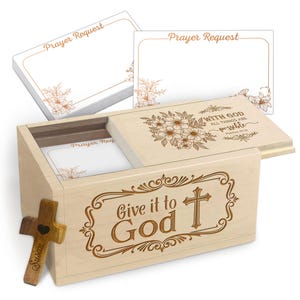 May include: A wooden prayer box with the words "Give it to God" and a cross engraved on the front. The lid features floral designs and the text "With God all things are possible." Includes a stack of "Prayer Request" cards.