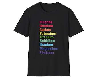 May include: A black short-sleeved t-shirt featuring a vertical list of chemical elements printed in rainbow colors. The text reads Fluorine, Uranium, Carbon, Potassium, Titanium, Rubidium, Uranium, Magnesium, and Platinum in a stacked column.