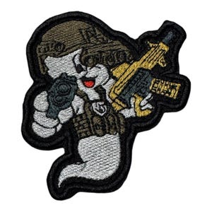 May include: Embroidered patch featuring a cartoon ghost character in military gear, holding a gun. The ghost wears a helmet and tactical vest, with a black border. The gun is gold and black, and the ghost has a red mouth.