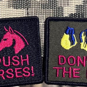 Könnte beinhalten: Zwei gestickte Aufnäher mit schwarzen Rändern. Einer zeigt einen rosa Pferdekopf und den Text "DON'T PUSH HORSES!". Der andere hat gelbe und blaue Handschuhe und den Text "DON'T FEED THE HORSES!".