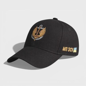 May include: A black baseball cap featuring an embroidered emblem on the front with a silver anchor and gold wings. The side of the cap displays the gold embroidered text "МП ЗСУ" followed by a small rectangular blue and yellow flag patch.
