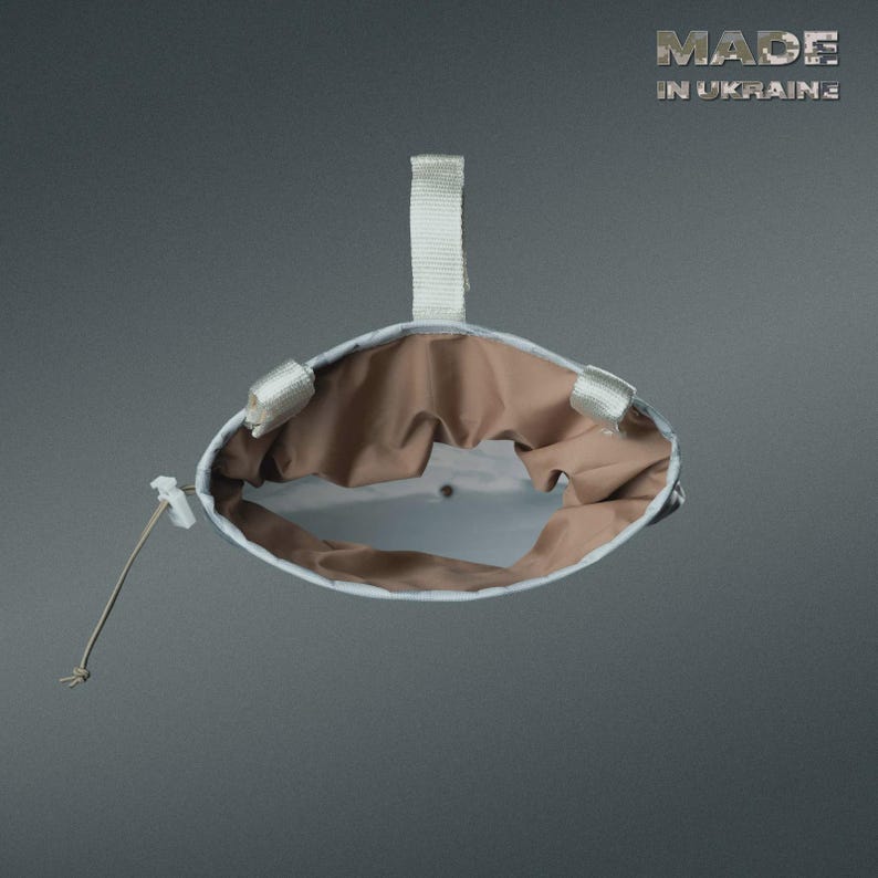 May include: A white and tan pouch with a drawstring closure and a white strap. The interior is tan, and the exterior is white with a subtle pattern. The text "MADE IN UKRAINE" is visible.