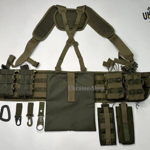 May include: An olive green tactical chest rig and belt system featuring adjustable shoulder straps, multiple modular pouches for magazines, a central utility pouch, and various attachment clips. The gear includes a Made in Ukraine logo.