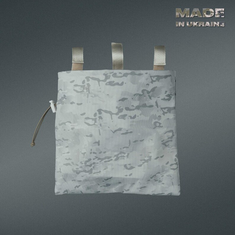 May include: A white and gray camouflage pouch with three tan straps at the top and a drawstring closure. The text "MADE IN UKRAINE" is visible in the upper right corner. The pouch is designed for carrying small items.