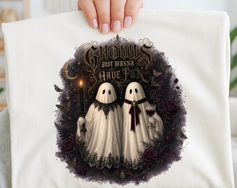May include: A white t-shirt featuring a graphic of two ghosts draped in white sheets with black lace trim. One ghost holds a lit candle, the other a glass of red wine. The text reads GHOULS JUST WANNA HAVE FUN, surrounded by dark roses and ferns.
