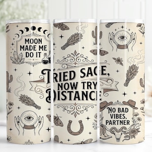 Puede incluir: Tres vasos beige con un patrón repetido de símbolos celestiales y místicos. Cada vaso presenta texto, incluyendo "Moon Made Me Do It", "Tried Sage, Now Try Distance" y "No Bad Vibes, Partner."