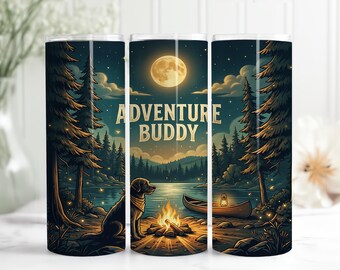 May include: A tumbler with a nature scene featuring a dog, campfire, canoe, and the words "Adventure Buddy." The design is set against a night sky with a full moon, trees, and a lake. The tumbler is cylindrical.