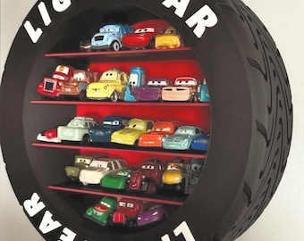Puede incluir: Un estante negro con forma de neumático con la palabra "LIGHTYEAR" en letras blancas. Tiene tres estantes rojos llenos de coches de juguete de varios colores. El neumático tiene un dibujo de la banda de rodadura.
