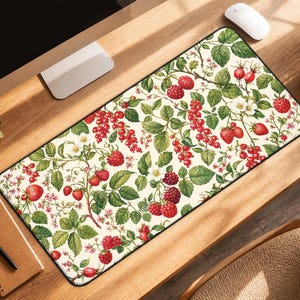 May include: A rectangular desk mat featuring a botanical print on a cream background. The pattern displays clusters of red raspberries, red currants, and small white flowers with green leaves, all arranged in a dense, repeating naturalistic design.