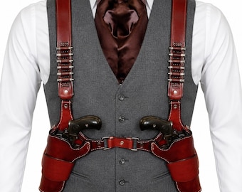 May include: A dark red leather double shoulder holster rig featuring integrated cartridge loops on each strap, worn over a grey button-up vest, a white collared shirt, and a dark brown satin cravat. The holster system holds two black revolvers.