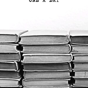 May include: Black and white image of stacked books. The text "ONE A DAY" is printed at the top. The books appear to be old, with worn covers and aged pages. The image is a close-up of the books, emphasizing their texture and the details of the pages.