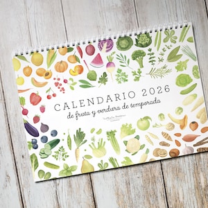 Puede incluir: Calendario de espiral para 2026 con ilustraciones de acuarela de frutas y verduras. El diseño presenta una variedad de productos, como melocotones, fresas y brócoli, dispuestos alrededor de los bordes. El título "CALENDARIO 2026" se muestra de forma destacada.