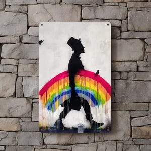 May include: A metal sign featuring a silhouette of a person walking under a rainbow. The person is wearing a top hat and coat. The rainbow is painted in vibrant colors. Two birds are flying above the person. The background is a light, off-white color.