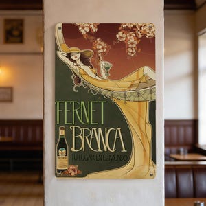May include: A vintage-style metal sign featuring a woman in a yellow dress reclining on a hammock, holding a drink. The sign has the words "FERNET BRANCA" and "TU LUGAR EN EL MUNDO" with a bottle illustration and floral accents.