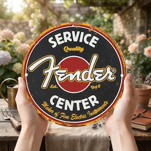 Può includere: Cartello rotondo Fender Service Center nero, rosso e giallo. Il cartello presenta il logo Fender in corsivo bianco, con le parole "Service", "Quality" e "Center" in lettere bianche. Ha uno stile vintage con una finitura invecchiata.