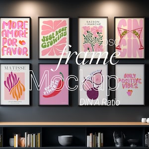 Könnte beinhalten: Acht gerahmte Kunstdrucke mit verschiedenen Designs und Texten, darunter "Just Keep Growing" und "Only Positive Vibes". Die Drucke zeigen farbenfrohe Illustrationen und Phrasen. Die schwarzen Rahmen kontrastieren mit dem Kunstwerk an einer dunkelgrauen Wand.