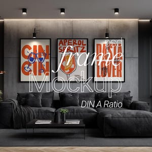 May include: A modern living room featuring a dark gray sectional sofa, a black coffee table, and three framed art prints. The prints have bold text and colorful illustrations. The room is decorated with a plant and a rug.