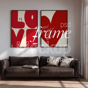 Könnte beinhalten: Zwei gerahmte Kunstdrucke mit rot-weißen Designs hängen über einem braunen Ledersofa. Ein Druck zeigt "LOVE" mit einer Hundeillustration, der andere ein rotes Herz mit Text. Die Worte "frame Mockup" sind überlagert.