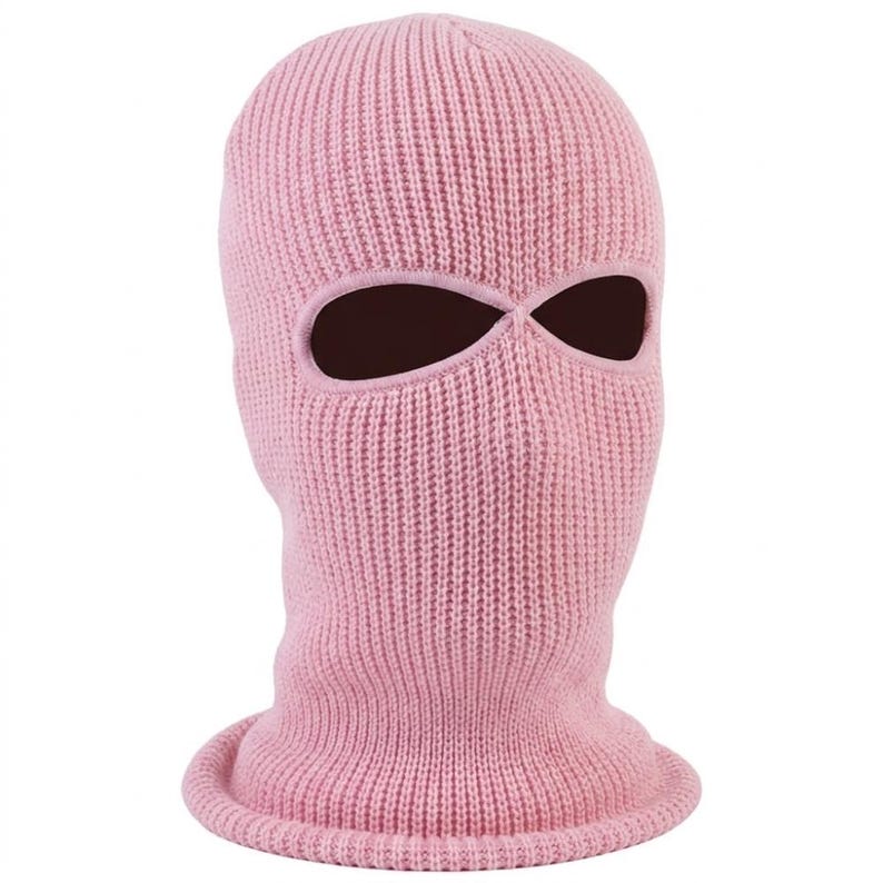 K&ouml;nnte beinhalten: Eine hellrosa Strick-Balaclava mit Augen- und Mund&ouml;ffnungen. Die Skimaske besteht aus einem Rippenstrickstoff. Die &Ouml;ffnungen sind dunkelbraun.